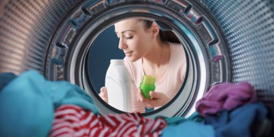 Žena čichá k aviváži před pračkou