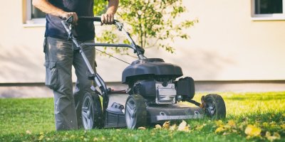 Muž seká trávník sekačkou