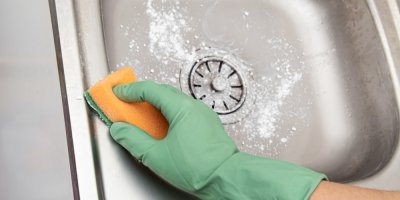 Čištění dřezu houbičkou a jedlou sodou