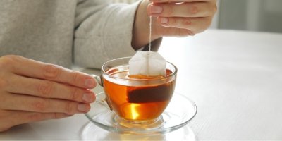 Šálek čaje se sáčkem, ženské ruce