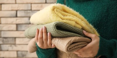 Žena drží tři různé svetry