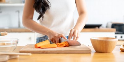 Krájení mrkve na dřevěném prkénku