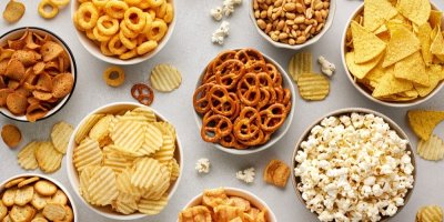 Různé druhy slaných pochutin v bílých miskách