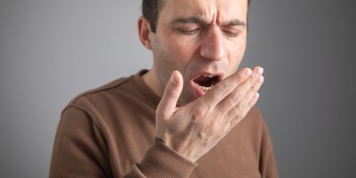 Muž dýchá do dlaně