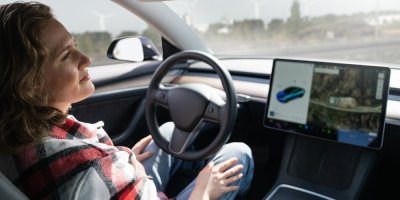 Žena sedící za volantem automatizovaného vozidla