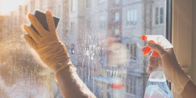 Záběr na ruce umývající houbičkou špinavá okna