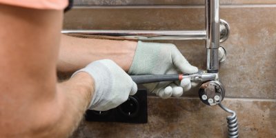 Technik instaluje koupelnový radiátor