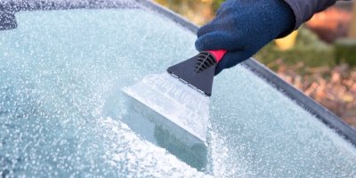 Ruka škrábající led z okna auta