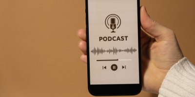Ruka držící mobilní telefon, poslech podcastu