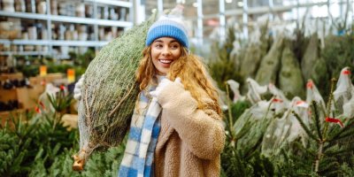 Mladá žena si kupuje vánoční stromek