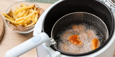 Smažení nugetek ve fritéze, miska s hranolkami