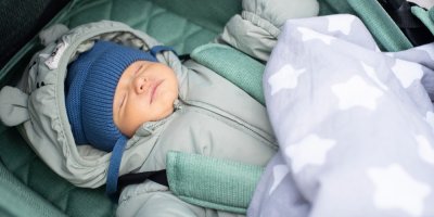 Miminko v zimním oblečení spí v kočárku