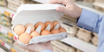 Muž v supermarketu drží balení vajec