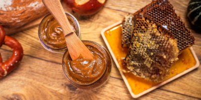 Dřevěná naběračka v medu, okolo plásty