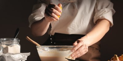 Žena mačká šťávu z citronu do těsta 