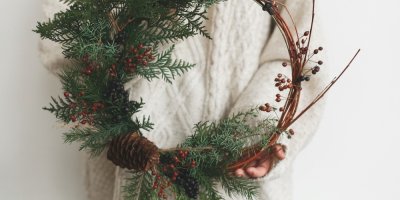 Žena drží vánoční věnec