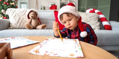Dítě v santovské čepici píše dopis
