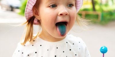 Dítě má modrý jazyk od lízátka