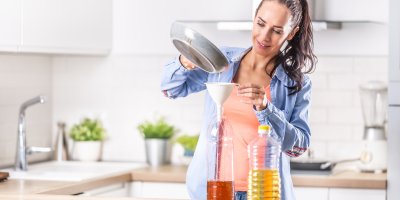 Žena vlévá použitý olej do PET lahve