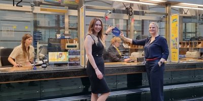 Přepážky České pošty, dvě usmívající se ženy držící cedulku PPL