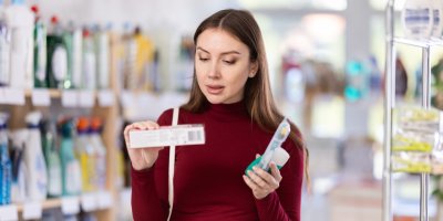 Žena v obchodě si vybírá zubní pastu