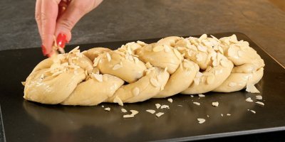 Ženská ruka sype na vánočku plátky mandlí