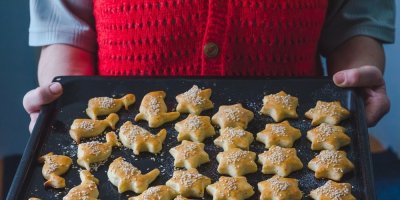 Žena drží pekáč se slaným vánočním cukrovím