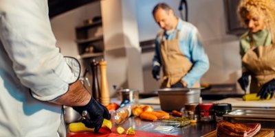 Muž a žena připravují jídlo na kurzu vaření 