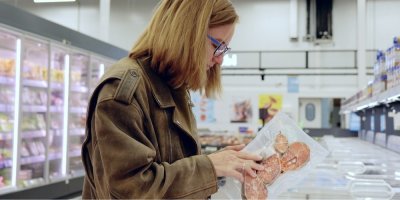 Zákaznice v supermarketu drží v rukou balení mražené porcované ryby