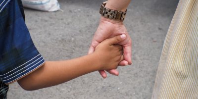 Dítě drží matku za ruku