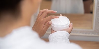 Žena používá krém na ruce