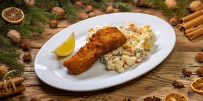 Bramborový salát se smaženou rybou na bílém talíři