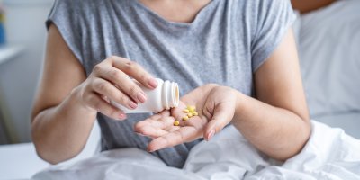 Žena si sype tablety do ruky