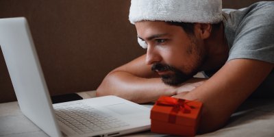 Smutný muž v santovské čepici před notebookem