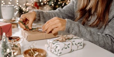 Žena balí na stole vánoční dárek