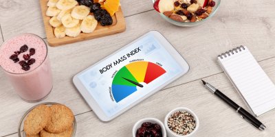 Tablet s grafikou BMI, okolo potraviny