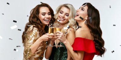 Tři ženy si ťukají sklenicemi se šampaňským
