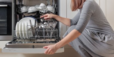 Žena otevírá myčku nádobí
