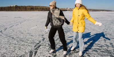 Dvě dívky bruslí na zamrzlé vodní ploše