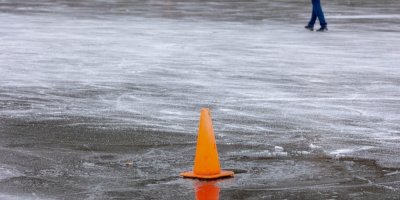 Oranžový výstražný kužel na zamrzlé vodní ploše
