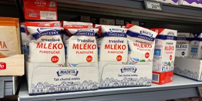 Pomačkané krabice mléka v regálu supermarketu