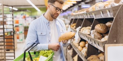 Mladý muž nakupuje v obchodě chléb