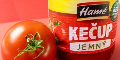 Detail čerstvého rajčete a sklenice kečupu Hamé