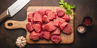 Kousky vepřového masa na dřevěném prkénku