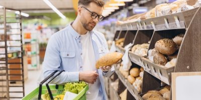 Mladý muž nakupuje v obchodě chléb