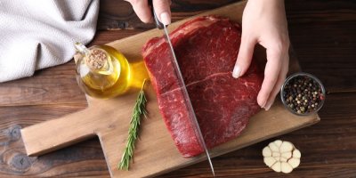 Krájení masa na dřevěném prkénku