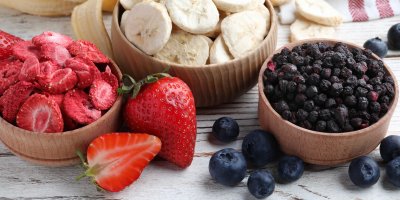 Dřevěné misky s lyofilizovanými jahodami, banány a barůvkami