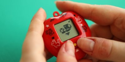 Ženské ruce držící hračku Tamagotchi