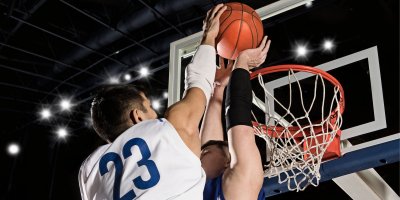 Dva basketbalisti hází míč do koše