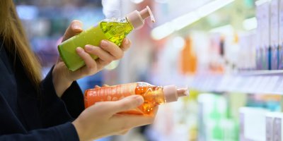 Dvě lahve s kosmetikou v rukou